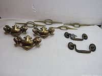 Photo showing all nine drawer pulls in three distinct styles arranged on a white background, inclusive of screws with some pulls missing screws.