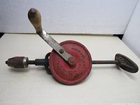 Full view of vintage Fleetway Clipper breast drill showing metal crank, red circular gear cover, steel shaft, and ergonomic breast support handle.
