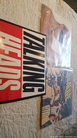 Three vinyl records with their original covers laid out on a surface. The album featuring Talking Heads is most prominent.