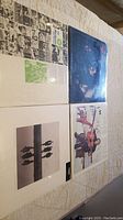Four sealed vinyl records including The Kingston Trio, Beatles, Simon & Garfunkel, and Bob Dylan laid on a surface showing album covers.