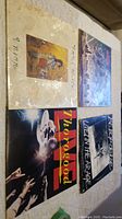 Four vinyl record albums laid out on a table, showing the front covers of each album.
