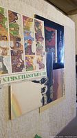 Photo of four vinyl record covers laid out, one with comic strip artwork visible