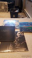 Four vinyl records laid out, showing front covers, each with distinctive artwork.