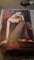 Full view of art print showing a seated woman with red flowers and blue background.