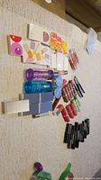 Wide view showing many Clinique beauty products arranged on surface including lipsticks, boxed products, cleansing oils, and small boxed color cosmetics.