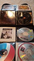Photo showing various CDs inside clear plastic sleeves in a binder: visible CDs include The Walkons, a jazz/swing album, and others.