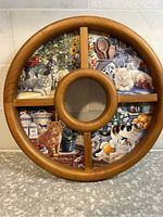 Front view of round wooden serving tray with four compartments, each featuring a tile decorated with cat images and cozy home scenes.