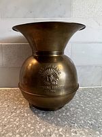Front view of vintage brass spittoon with embossed Bull Brand Chewing Tobacco logo