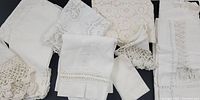 Overview of nine ivory vintage linens including some with monograms, crochet lace, cutwork and fine embroidery.
