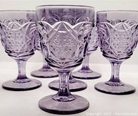 Six lavender pressed glass goblets arranged in two rows showing front view