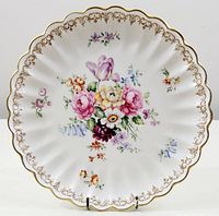 Top-down view of the plate showing the central bouquet floral pattern, scalloped edge, and gold detailing on the rim.