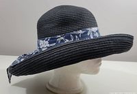 Side angle of navy blue vintage hat showing wide brim and floral bow.