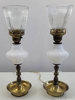 Two vintage brass and milk glass lamps side by side showing full height and design details