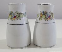 Front view of vintage Noritake Nitto Ware salt and pepper shakers showing the fruit and leaf pattern with silver trim.