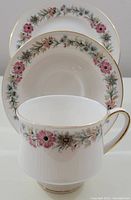 Photo showing teacup, saucer, and side plate with floral design and gold trim