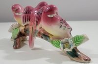 Angled close-up showing the trio of pink birds on the branch with flowers and leaves, highlighting hand-painted details and glazed finish.