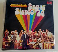 Front cover of James Last Super Stereo 74 vinyl record album with colorful rainbow design and band performing on stage.