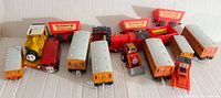 Full view of the lot with multiple vintage Thomas The Train toy cars and vehicles including yellow engine, red tractor, Wonderland Express cars.