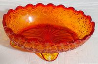 Photo of amberina glass candy dish showing scalloped rim and starburst pattern on the base.