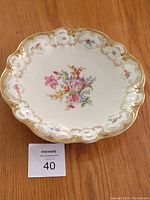 Top view of the large porcelain bowl showing scalloped edges with gold trim and center floral pattern.