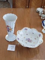 Image showing both the Royal Tettau floral vase and the Reichenbach footed fruit bowl displayed on a wooden table.