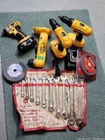 Full lot overview showing cordless power tools, charger, wrench set, grinder stones.