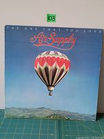 Front cover of Air Supply vinyl LP 'The One That You Love'. Shows hot air balloon with heart motifs against blue sky.
