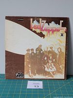 Front of Led Zeppelin II album jacket showing band photo with airship graphic and bright pink lettering.