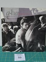 Front cover of a-ha Hunting High and Low LP showing band members and artistic elements.