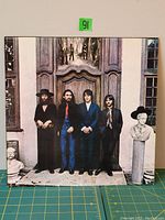 Front cover of the vinyl LP jacket showing The Beatles standing in front of a large door with bust sculptures on each side.