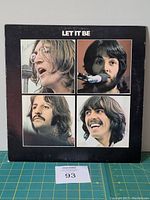 Front cover of The Beatles Let It Be vinyl LP album, showing portraits of band members and title.