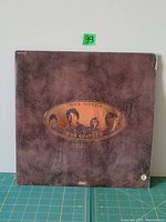 Front cover of The Beatles Love Songs LP jacket in distressed brown leather-style with portraits of the band in oval cutout.