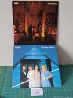 Front view of two ABBA LP vinyl album jackets stacked, showing 'The Visitors' on top and 'Voulez-Vous' partially under.