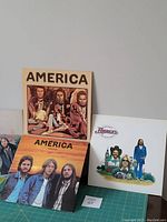 Four vinyl LP records from the band America with original jackets featuring artwork and portraits.