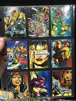 Close-up photo of 9 Wolverine trading cards in a plastic sleeve showing vibrant comic-style artwork of Wolverine and other characters.