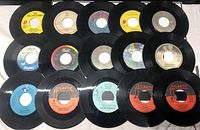 Photo showing 15 of the 38 rock 45 RPM vinyl records with labels visible, including The Rolling Stones and John Prince.
