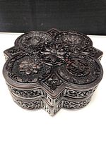 Top view showing intricate floral and geometric carvings on the lid of the dark wooden box