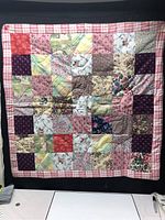 Full view of the Yorkshire Rose Quilt showing the patchwork fabric squares and checkered border