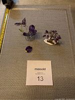 Photo of both amethyst tree and glass hummingbird trinket on textured mat with measuring tape for scale