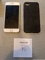 White Apple iPhone 8 front view with screen off next to black textured phone case.