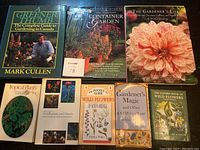 Top-facing view of eight gardening and flower books arranged flat showing full covers, titles and authors.