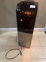 Front view of the GE Profile water cooler with visible three water dispenser taps and stainless steel body.
