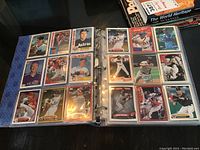 Open binder showing two pages of baseball cards featuring players from different teams, including Astros and Mariners.