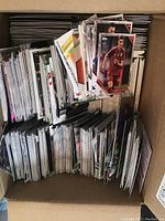 Box filled with assorted soccer collectible cards stacked vertically and horizontally