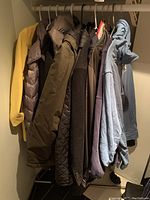Photo showing several jackets in various colors including yellow, black, olive green, and navy on hangers