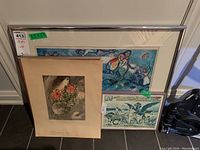All prints shown in group, three framed, one unframed, leaning against wall