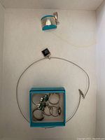 Photo of sterling silver turquoise pendant and square black onyx pendant necklace with box containing seven rings