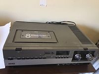 Top and front view of the RCA VGT 200 video cassette recorder with a Polaroid video cassette inserted.