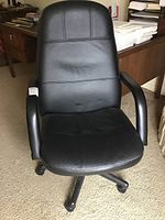 Front view of a black faux leather office chair showing padded seat and backrest, armrests and caster wheels on a rolling base