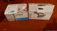 Two boxes on floor showing one Moen Adler L82839 faucet box and another PlumbShop bathroom shower combo box.